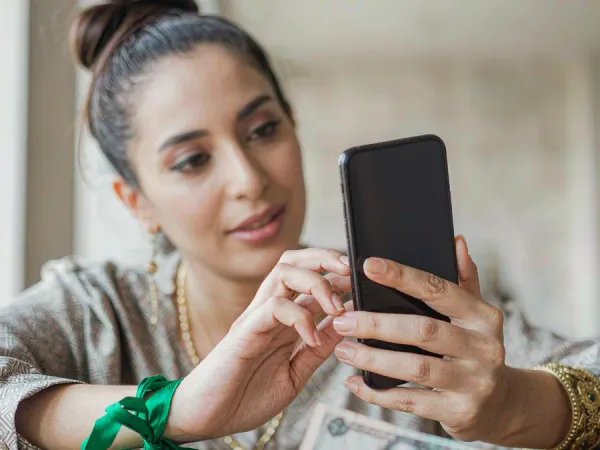 six6s + Hands holding a smartphone with an abstract payment screen