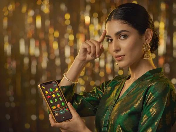 six6s + Woman holding a phone showing fruit and bell slot reels